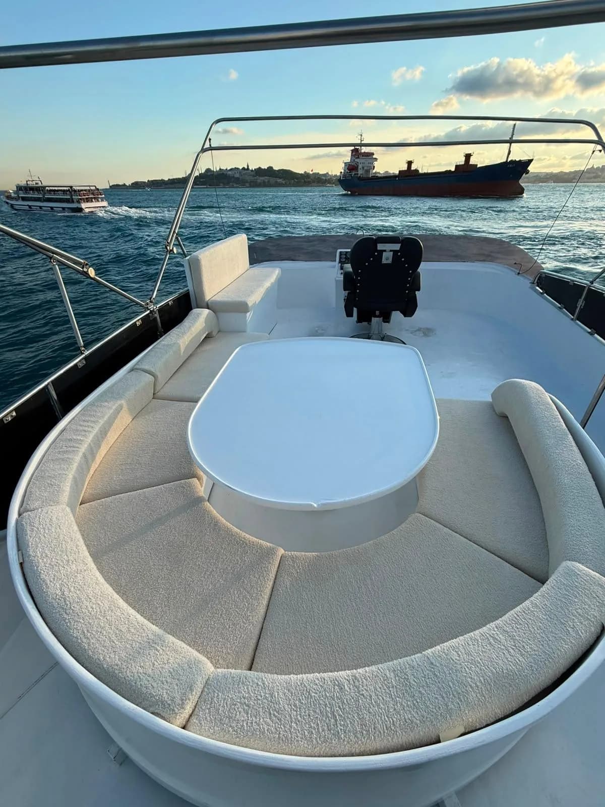 The bow lounge of a Luma charter yacht, cushioned seating facing the open Bosphorus